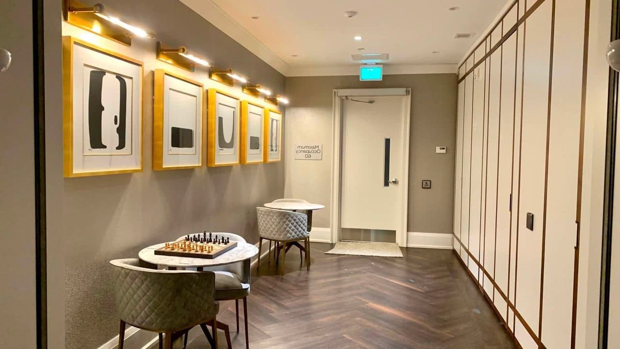 Condo amenity corridor with framed artwork and wood floors after a professional clean by Pro City Maids